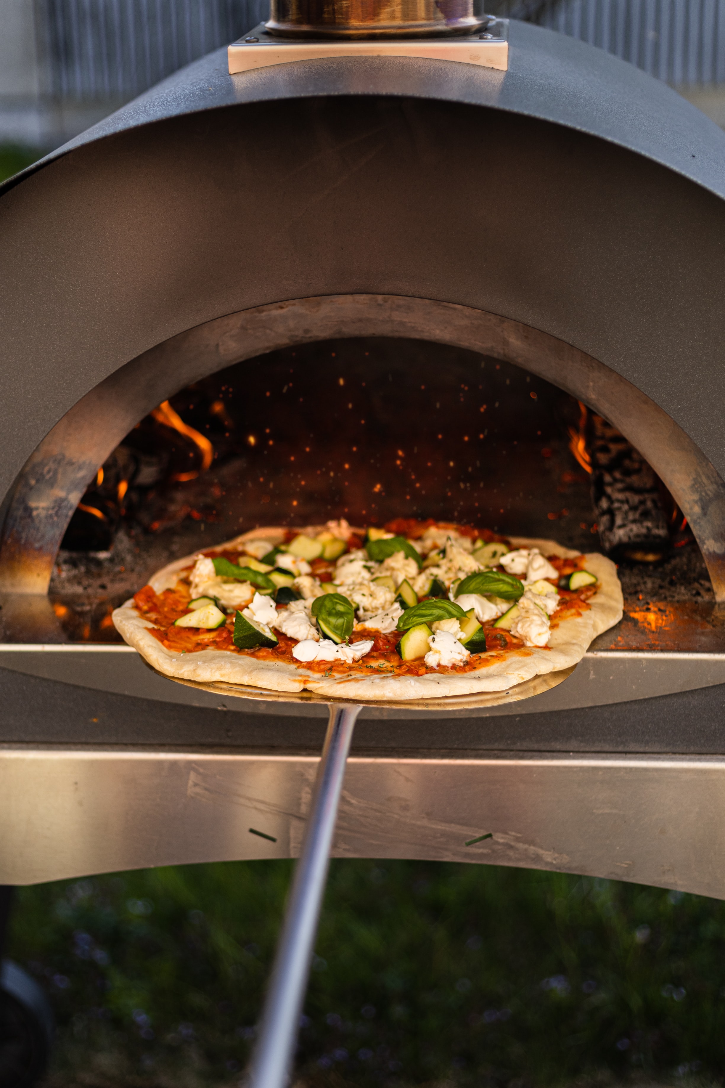 A pizza going in the oven