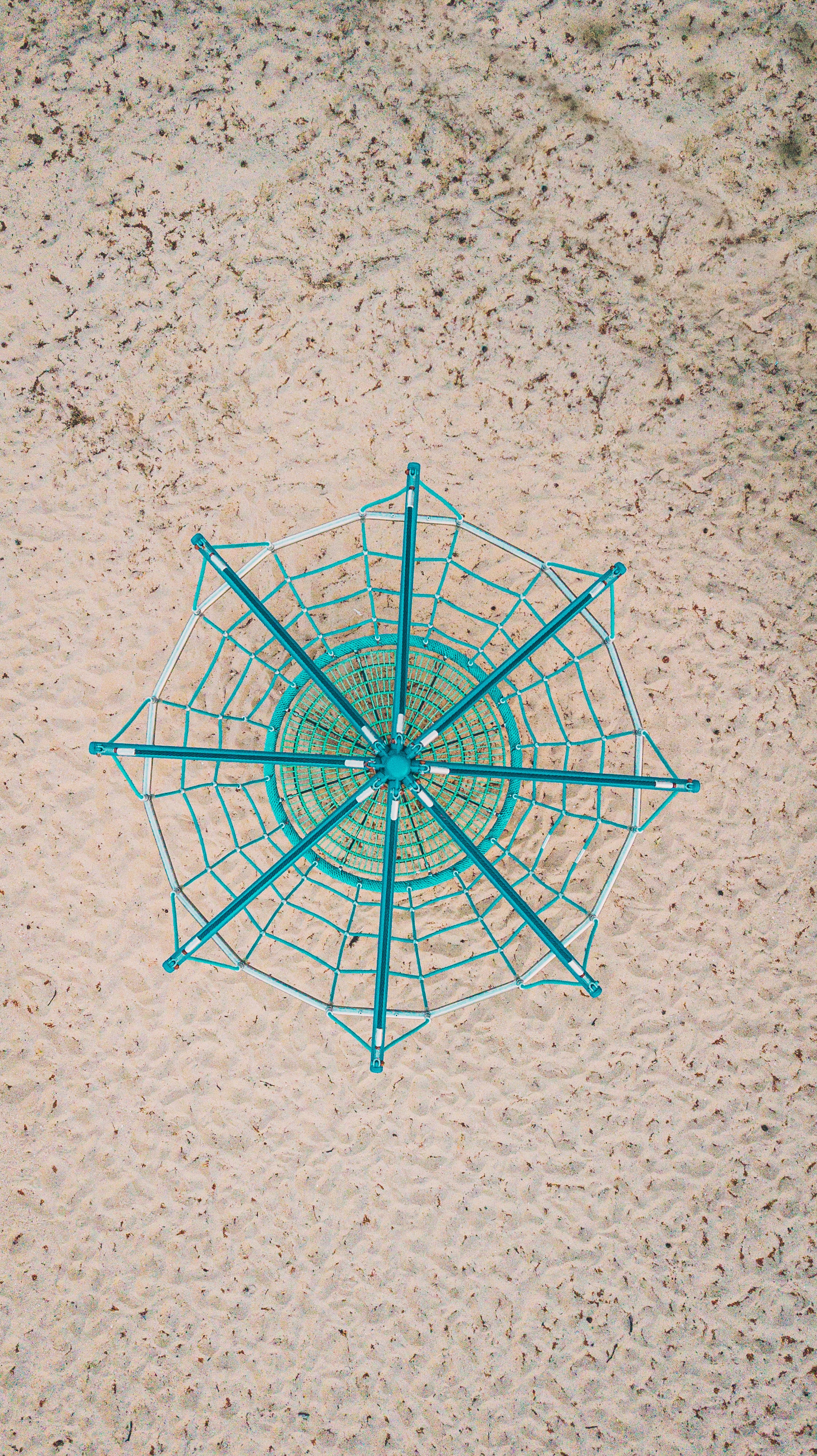 A blue geometrical shape on a beach seen from above