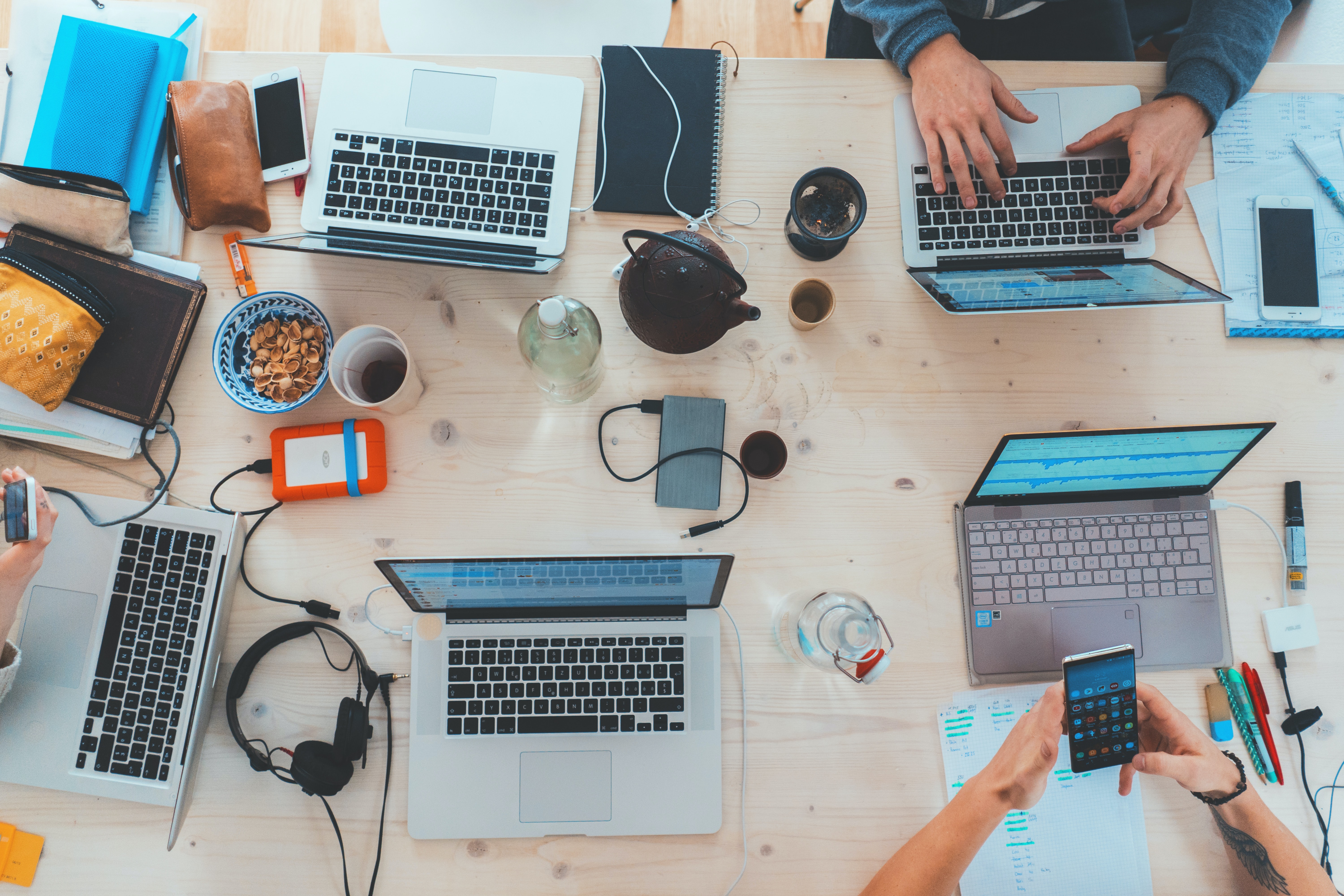 People working on laptops all around the same table seen from above