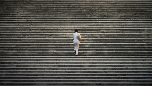 A lady walking up a concrete stairway